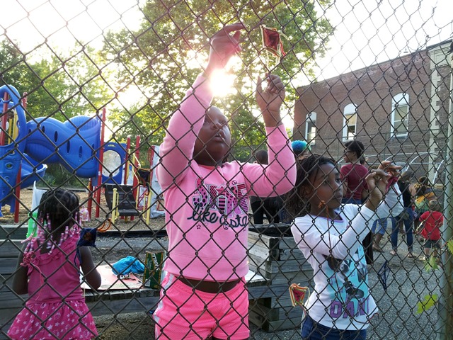 Weaving Protective Eyes, Ojo de Dios, into the Boggs School fence, August 2014, Detroit